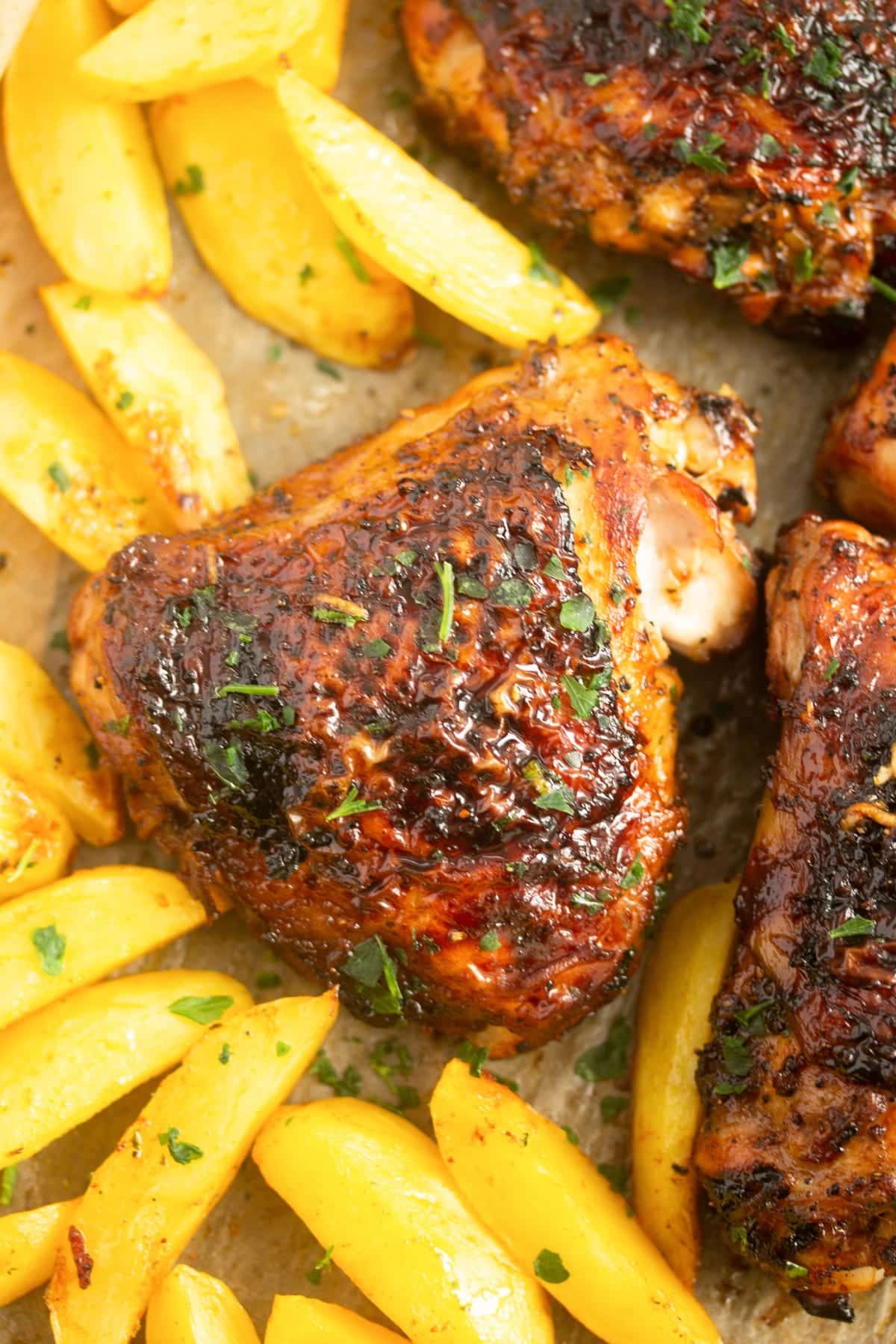 overhead view of crispy brown thighs with potato slices.